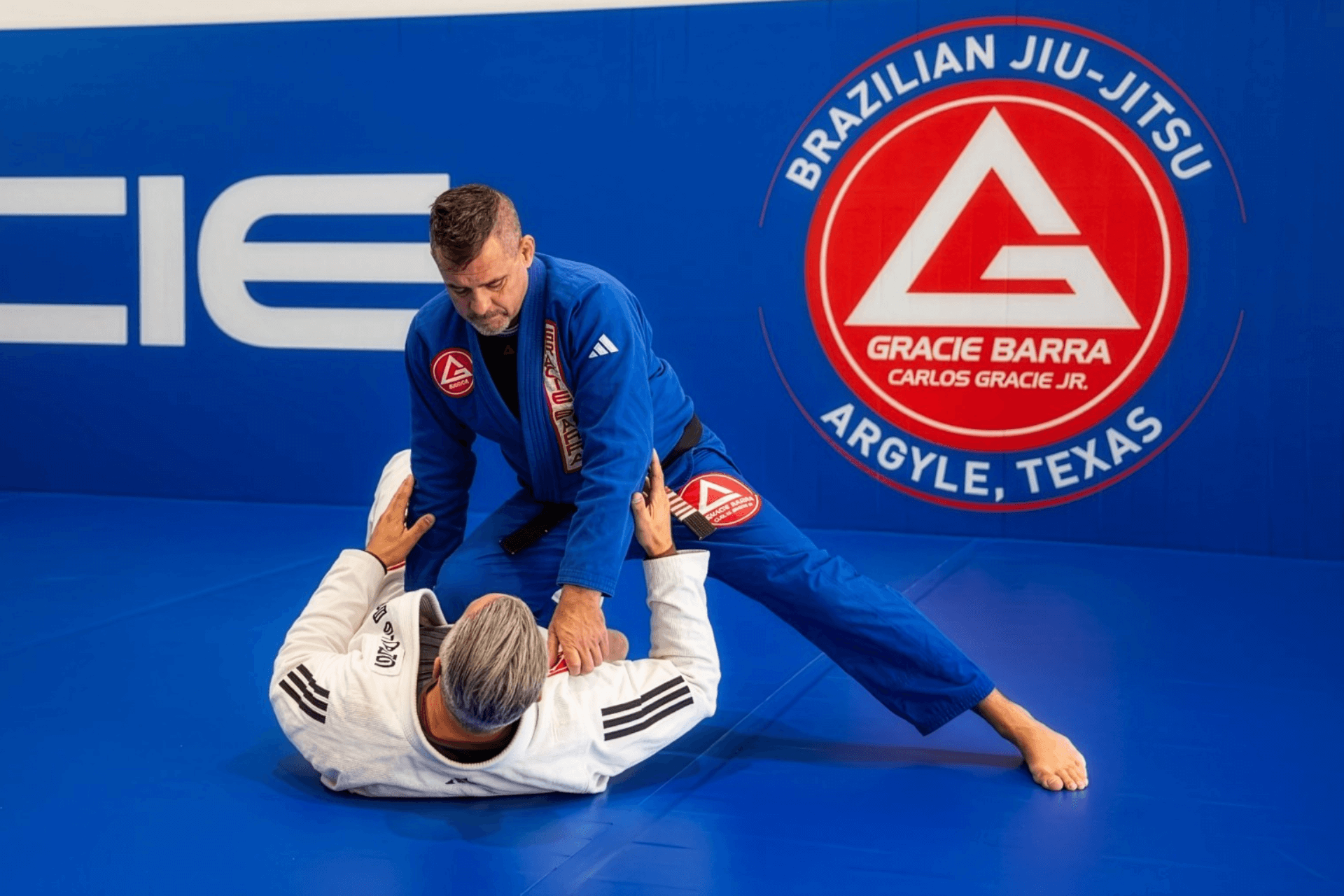 Professor Alejandro Siqueira and Coach Ryan Kagay demonstrating Brazilian Jiu-Jitsu technique at Gracie Barra Argyle in Argyle TX