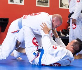 Students practicing technique and positional drills during adult Jiu-Jitsu class at Gracie Barra Argyle. Two men training Brazilian Jiu-Jitsu during adult class at Gracie Barra Argyle in Argyle TX