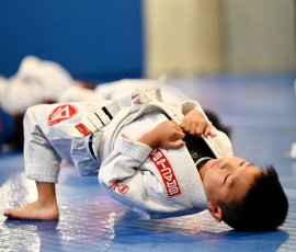 Student working on drills and teamwork during kids’ class. Boys practicing Brazilian Jiu-Jitsu during kids’ class at Gracie Barra Argyle