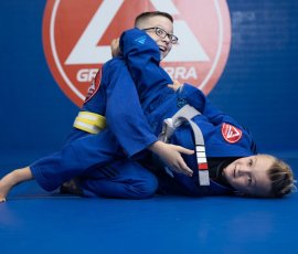Students working on technique and teamwork during kids' martial arts class. Boys practicing Brazilian Jiu-Jitsu techniques at Gracie Barra Argyle